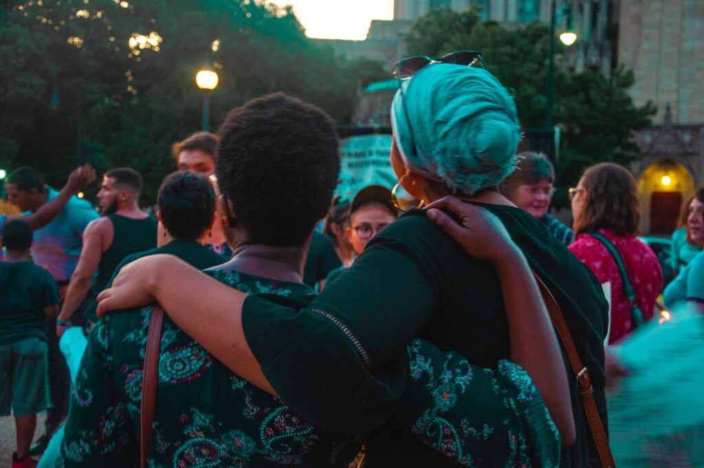 Friends hugging each other at a festival. Making friends is a great benefit of travel and can heal your life.