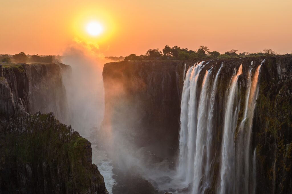 Victoria Falls at sunset. Spending time in nature is one of the many ways travel can be healing to your life. 